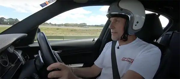 Driver in a helmet behind the wheel at Hampton Downs